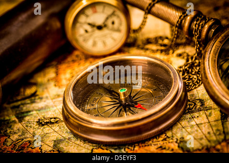 Vintage still life. Vintage boussole se trouve sur une ancienne carte du monde. Banque D'Images