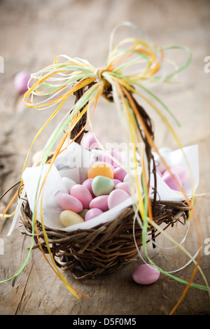 Bonbons De pâques Colorés en brun panier avec ruban Banque D'Images