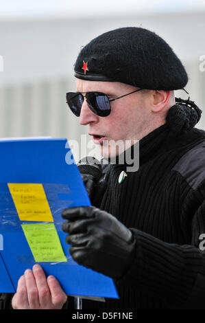 Un homme portant uniforme paramilitaire républicaine irlandaise se lit de l'AIDN tableau d'honneur lors de l'Insurrection de Pâques commémoration annuelle à Milltown Cemetery, Belfast, Irlande du Nord. Banque D'Images