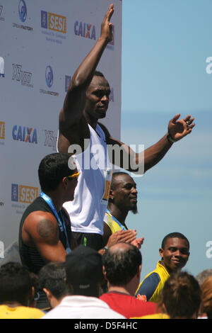 Jamaican Usain Bolt célèbre sa victoire dans le 150m 'Mano-a-mano' challenge, flanquée par Bruno Lins (Brésil), Daniel Bailey (Antigua et Barbuda) et Alex Quiñonez (Équateur). 31 mars 2013, Rio de Janeiro, Brésil. Banque D'Images