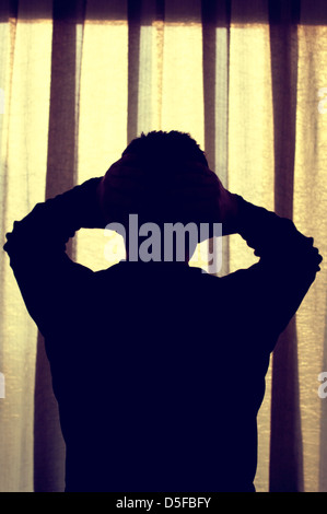 Silhouette d'un homme déprimé head in hands Banque D'Images