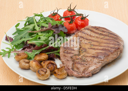 Ribeye Steak grillé servi avec des feuilles de salade, champignons et tomates grillées sur la vigne - studio shot Banque D'Images