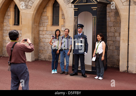 L'Angleterre, Berkshire, Windsor, Castle Hill, oriental touristes posant avec Royal Air Force Regiment guardsman Banque D'Images