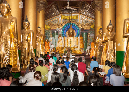 Les fidèles priant à l'intérieur d'une salle de prière à la pagode Shwedagon à Yangon (Rangoon), le Myanmar (Birmanie), Banque D'Images