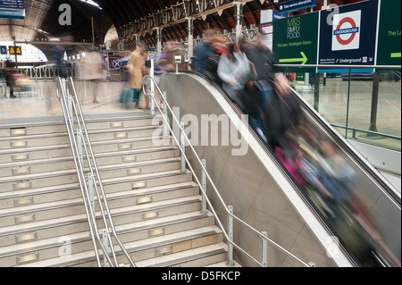 Les navetteurs à Paddington street station pendant les heures de pointe font leur chemin vers le bas escalator et pas du centre de la gare Banque D'Images