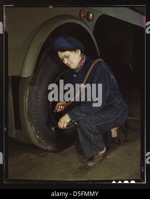 Les travailleurs de la production de guerre de la Heil Company qui font des chars de remorquage à essence pour le US Army Air corps., Milwaukee, Wisconsin. Mme Angeline Kwint, 45 ans, ex-femme au foyer, qui vérifie les pneus des remorques. Son mari et son fils sont dans l'armée américaine (LOC) Banque D'Images