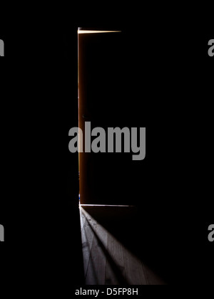 Porte ouverte à la fin d'un couloir sombre en laissant un peu de lumière dans un creux menaçant et effrayant way Banque D'Images