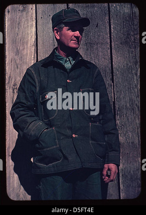 Portrait d'un homme d'âge moyen portant une casquette et une salopette, probablement un fermier des années 1940 La photographie capture un mode de vie agricole rural durant cette période. Banque D'Images