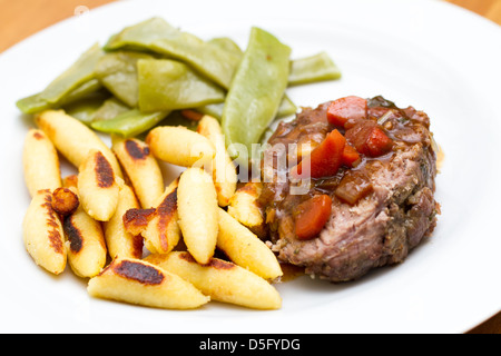 Gigot d'agneau en forme de doigt boulettes de pommes de terre et haricots de printemps Banque D'Images