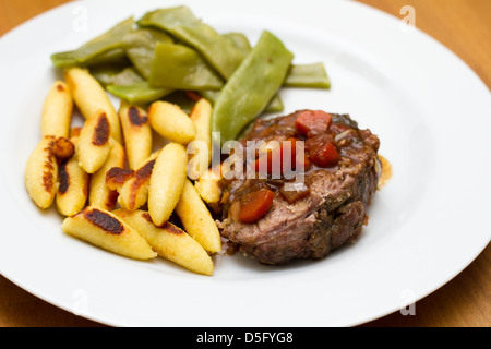 Gigot d'agneau en forme de doigt boulettes de pommes de terre et haricots de printemps Banque D'Images