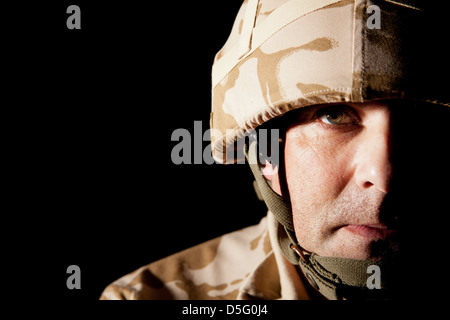 Portrait d'un soldat britannique. Le soldat est spotlit créant des ombres profondes pour une image plus dramatique. Banque D'Images
