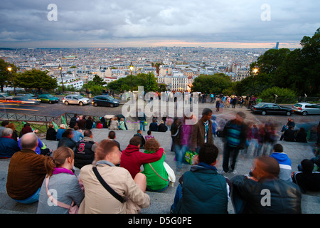 Les gens dans les escaliers de la Basilique du Sacré-Cœur profitez de la vue sur Montmartre et Paris au crépuscule Banque D'Images