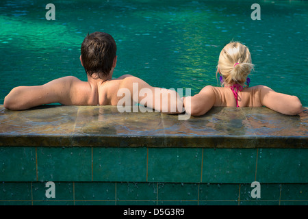 Vue arrière du couple dans une piscine sur un pool in tropical resort