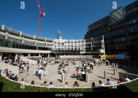 Les travailleurs bénéficiant d'une piscine en plein air de la ville déjeuner au Broadgate et Exchange Square, à proximité de la gare de Liverpool Street, Londres, Angleterre. Banque D'Images