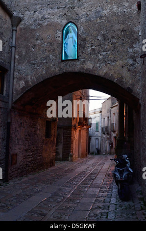 Statue illuminée au-dessus de la rue dans le village historique d'Erice, Italie. Banque D'Images