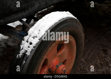 Old vintage Fordson E27N, sa roue avant du tracteur avec des pneus sur la neige. Roue en fonte orange. Banque D'Images