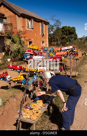 Madagascar, Ambatolampy, examinant les camions de jouets fabriqués à partir de boîtes de conserve sur le champ Banque D'Images