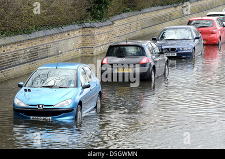 Voitures stationnées dans la banlieue inondée road London Banque D'Images