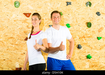 Femme et homme debout au mur d'escalade et souriant Banque D'Images