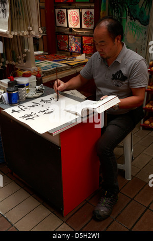 Calligraphie chinoise artiste à l'œuvre dans le Marché Central, Kuala Lumpur, Malaisie Banque D'Images