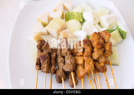 Mouton et Poulet Satay avec Concombres oignons hachés et Ketupat Vertical gâteau de riz Banque D'Images