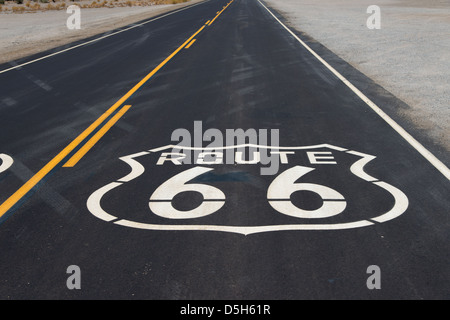 Un itinéraire Autoroute 66 shield peint sur une nouvelle route dans le désert californien Banque D'Images