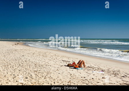 Madagascar, Morondava, plage, seule femme en train de bronzer sur une plage vide touristique Banque D'Images