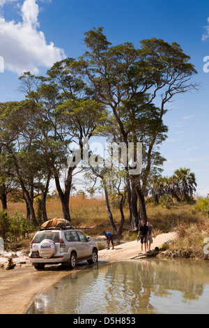 Madagascar, l'exploitation, transport étudiant Wallacea 4x4 véhicules traversant la rivière Mariarano ford Banque D'Images