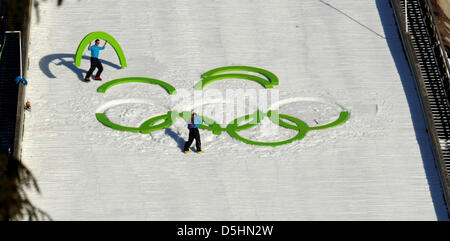 Les ouvriers placent les anneaux olympiques sur la neige de la grande colline d'atterrissage durant la compétition de saut à ski au parc olympique de Whistler durant les Jeux Olympiques de 2010 à Vancouver à Whistler, Canada, 19 février 2010.  + + +(c) afp - Bildfunk + + + Banque D'Images