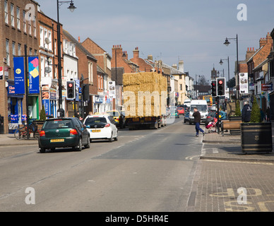 Y compris trafic remorque transportant de la paille dans la High Street, Newmarket, Suffolk, Angleterre Banque D'Images