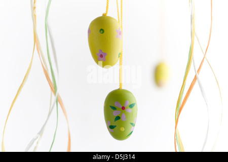 Les oeufs de Pâques colorés accroché sur fond blanc Banque D'Images