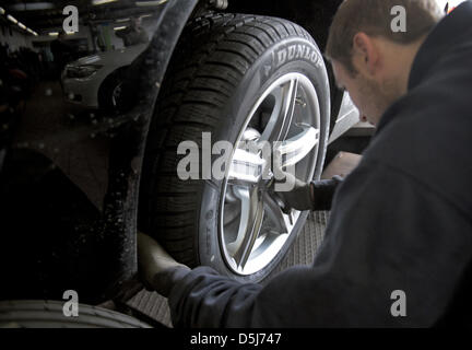 Un mécanicien automobile installe des pneus d'hiver sur une voiture à Neuss, Allemagne, 16 novembre 2012. Il y a un soi-disant service de pneus d'hiver de la situation. Voitures sans pneus d'hiver ne sont pas autorisés à conduire sur la voie publique en cas de neige, neige fondante ou la glace noire. Photo : Daniel Naupold Banque D'Images