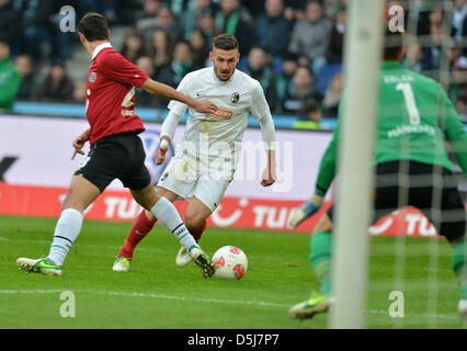 Lars Stindl Hannover (L) rivalise pour le bal avec Fribourg Daniel Caligiuri alors que Hannover gardien Ron-Robert Zieler (R) regarde sur pendant le match de football de la Bundesliga entre Hannover 96 et SC Freiburg à l'AWD-Arena à Hanovre, Allemagne, 17 novembre 2012. Photo : CARMEN JASPERSEN (ATTENTION : EMBARGO SUR LES CONDITIONS ! Le LDF permet la poursuite de l'utilisation de jusqu'à 15 photos uniquement Banque D'Images