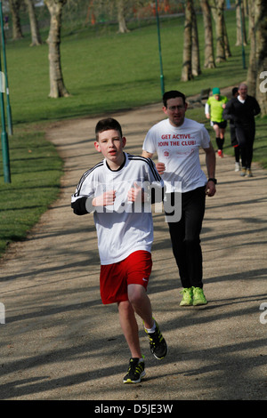 Un groupe de coureurs participent à un 5km dans un parc de Londres. C'est promu par une organisation mondiale appelée Parkrun. Banque D'Images