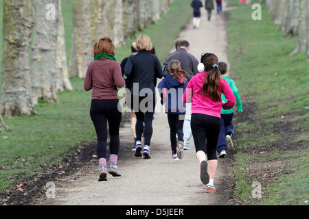 Un groupe de coureurs participent à un 5km dans un parc de Londres. C'est promu par une organisation mondiale appelée Parkrun. Banque D'Images