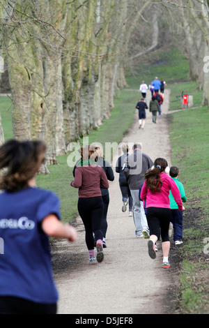 Un groupe de coureurs participent à un 5km dans un parc de Londres. C'est promu par une organisation mondiale appelée Parkrun. Banque D'Images