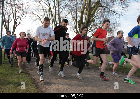 Un groupe de coureurs participent à un 5km dans un parc de Londres. C'est promu par une organisation mondiale appelée Parkrun. Banque D'Images