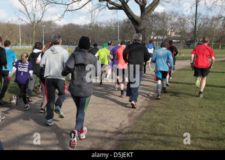 Un groupe de coureurs participent à un 5km dans un parc de Londres. C'est promu par une organisation mondiale appelée Parkrun. Banque D'Images