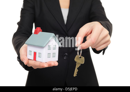 Business Woman in suit holding nouvelles clés de maison et un mini-modèle de maison isolé sur fond blanc Banque D'Images