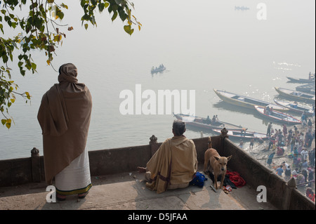Un homme regarde tandis qu'un autre médite, le premier jour de Kumbh Mela, Varanasi, Inde. 2013 Banque D'Images