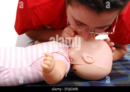 Instructeur de secourisme démontrant la respiration artificielle à l'aide de mannequin nourrisson Banque D'Images