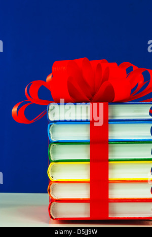 Pile de livres colorés attachés avec du ruban rouge Banque D'Images