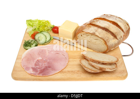 Pain rustique et de sandwich ingrédients sur une planche en bois isolés contre white Banque D'Images