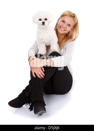 Cute young girl avec son bichon bolognese chien à la recherche de l'appareil photo Banque D'Images