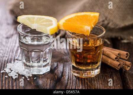 Tequila or et argent avec la cannelle et le sel sur fond de bois Banque D'Images