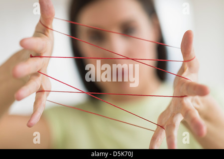 Woman playing cat's cradle Banque D'Images