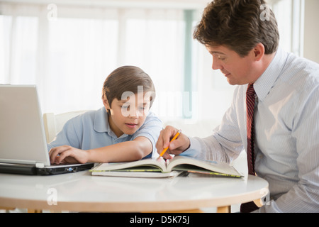 Père et fils (8-9) à faire leurs devoirs Banque D'Images