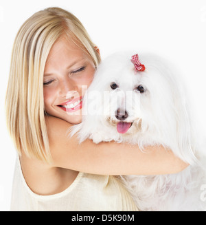 Studio Shot, Portrait of young woman holding dog Banque D'Images