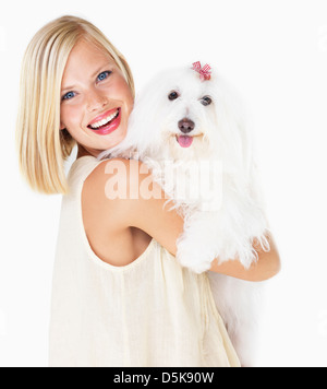 Studio Shot, Portrait of young woman holding dog Banque D'Images