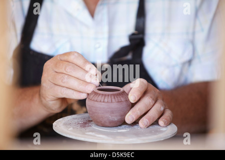 Close-up of male potter holding petit vase, sculpture Banque D'Images